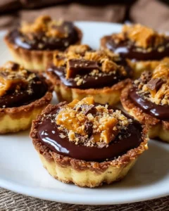 Delicious Butterfinger Caramel Crunch Mini Pies topped with caramel and chocolate