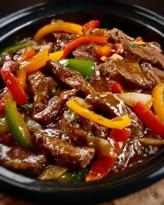 Delicious Pepper Steak cooked in a Crock Pot, featuring tender beef and colorful vegetables.