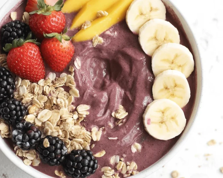 Homemade acai bowl topped with fresh fruits and granola in a vibrant bowl.