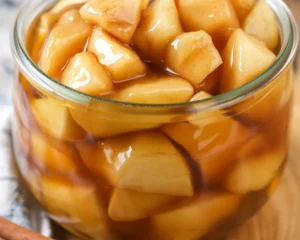 Homemade apple pie filling with cinnamon and brown sugar in a saucepan.
