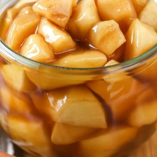 Homemade apple pie filling with cinnamon and brown sugar in a saucepan.