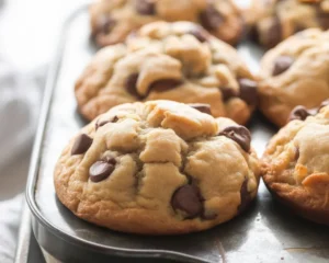 Freshly baked chocolate chip muffins topped with extra chocolate chips and sugar.