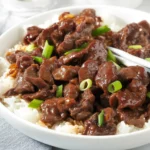 Delicious Mongolian Beef stir-fry served on a plate with vegetables.