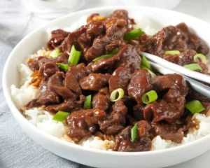 Delicious Mongolian Beef stir-fry served on a plate with vegetables.