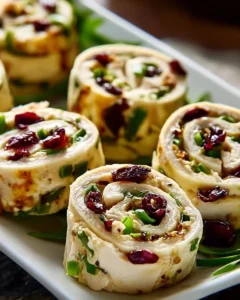 Creamy Chicken Cranberry Pecan pinwheels served on a plate