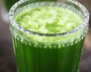 Healthy green juice made with kale, cucumber, celery, and apples in a glass