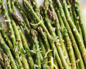 Plate of sautéed garlic butter asparagus garnished with Parmesan cheese.