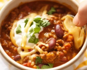 Delicious chili con carne topped with fresh cilantro and served in a rustic bowl