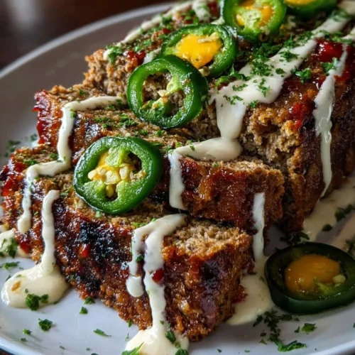 Smoky jalapeño popper meatloaf with creamy ranch drizzle on a plate