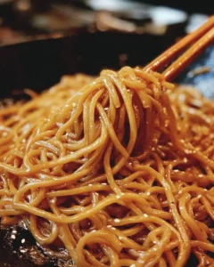 Delicious plate of hibachi noodles presented with vibrant vegetables and sauce