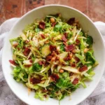 Fresh brussel sprout salad with nuts and cranberries on a wooden table