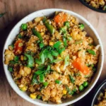 Bowl of delicious cauliflower fried rice with vegetables and herbs.