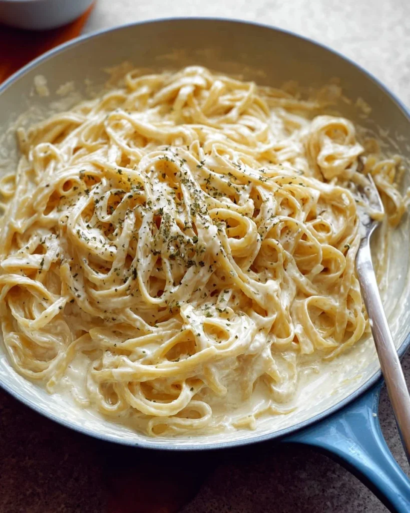 Bowl of homemade Alfredo sauce ready to serve with pasta.