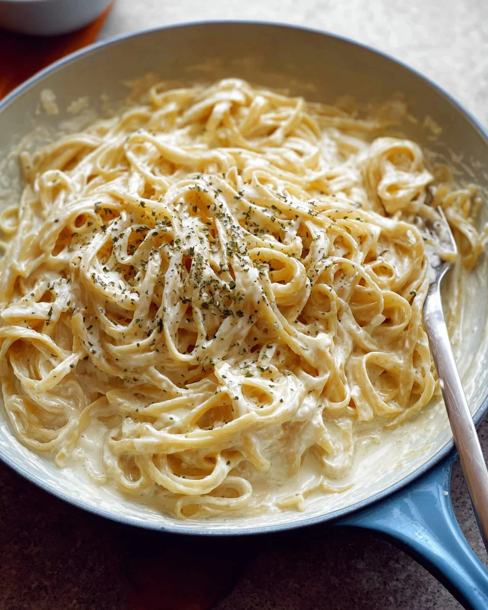 Bowl of homemade Alfredo sauce ready to serve with pasta.