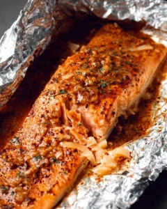 Delicious maple dijon baked salmon in foil on a plate garnished with herbs