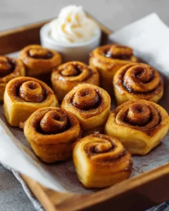 Delicious mini cinnamon rolls topped with icing on a plate