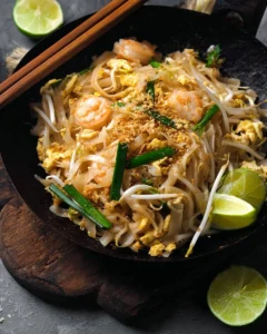 Plate of authentic Pad Thai noodles with shrimp, tofu, and fresh herbs