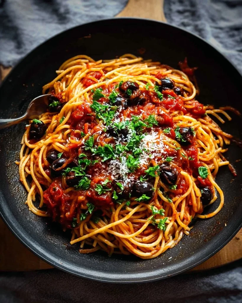 A delicious plate of Spaghetti alla Puttanesca garnished with parsley.