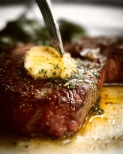 Café de Paris steak with butter sauce served on a plate, showcasing its rich textures.