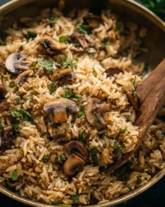 Cooked Mushroom Rice served in a bowl with fresh herbs.