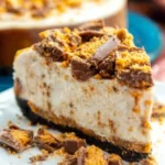 Delicious Butterfinger Cheesecake topped with chocolate and crushed Butterfinger bars