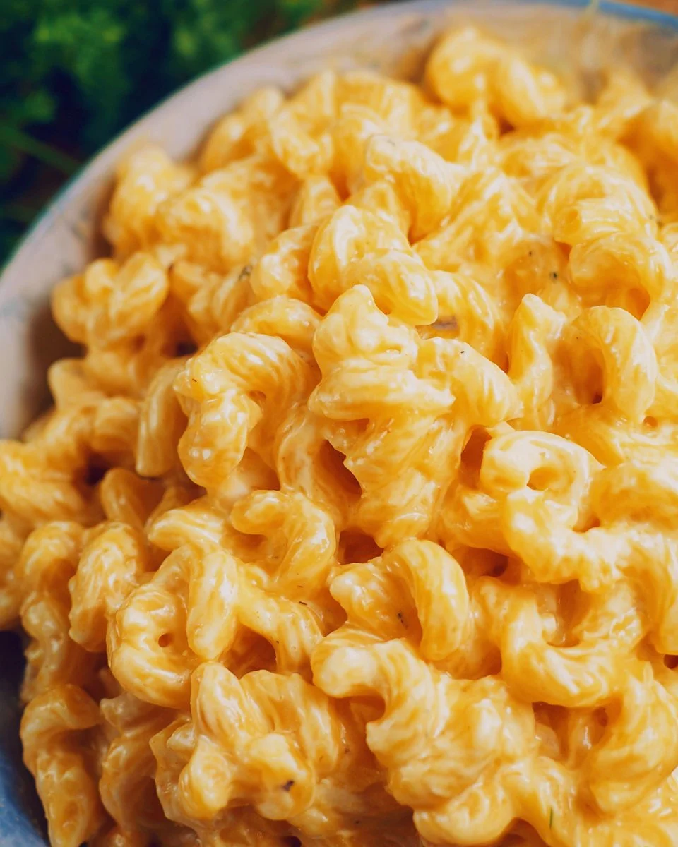 Bowl of creamy mac and cheese topped with breadcrumbs and herbs