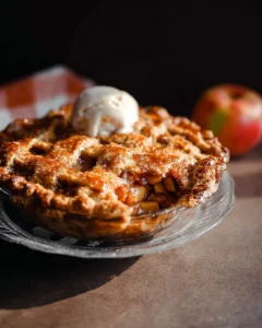 Dutch Caramel Apple Pie with caramel drizzle and apple filling on a rustic wooden table.