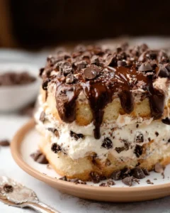 Slice of delicious easy cannoli cake topped with colorful sprinkles and cream