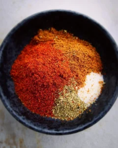 Homemade taco seasoning mix in a bowl with spices and herbs