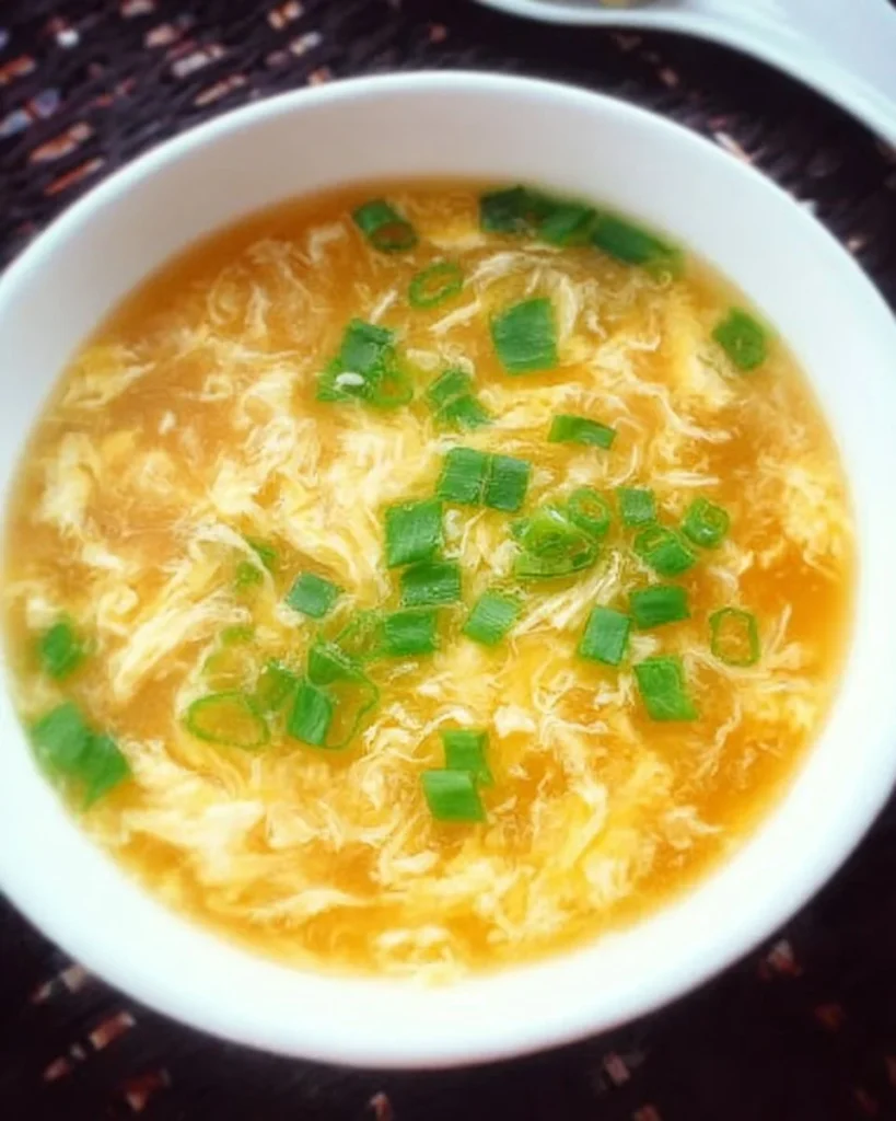 Bowl of homemade egg drop soup with green onions and tofu