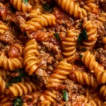 One pot beef taco pasta dish topped with cheese and herbs