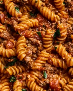 One pot beef taco pasta dish topped with cheese and herbs