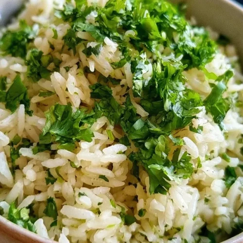 Fluffy Cilantro Lime Rice 2 Bowl of cilantro lime rice garnished with cilantro and lime wedges.