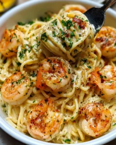 Creamy shrimp scampi garlic pasta garnished with fresh herbs.