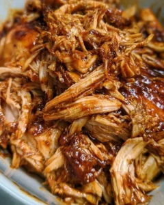 Slow Cooker BBQ Pulled Chicken served on a plate with coleslaw.