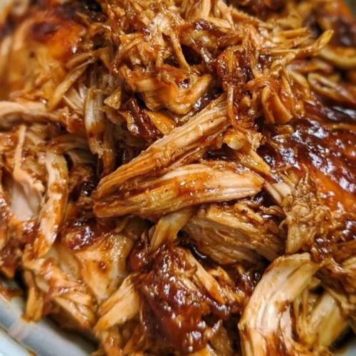 Slow Cooker BBQ Pulled Chicken Sandwiches 2 Slow cooker BBQ pulled chicken sandwich on a bun with coleslaw