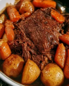 Slow cooker pot roast with carrots and potatoes served in a bowl.